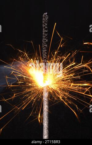 Burning sparkler isolato su sfondo nero. foto macro. Foto Stock