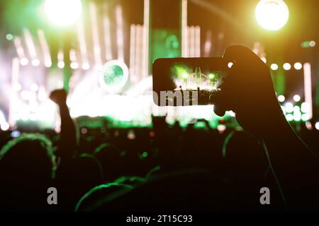 Acquisizione di foto o contenuti video durante un concerto musicale con un telefono cellulare. Foto Stock