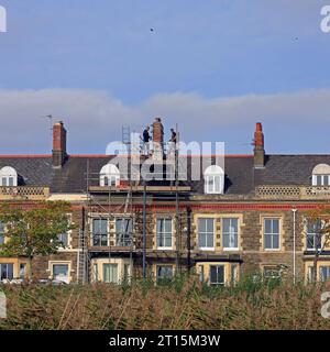 Due uomini su impalcature che lavorano su un camino, Windsor Esplanade, Cardiff Bay, Galles del Sud. Presa nell'ottobre 2023. Foto Stock