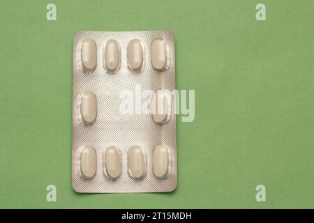 Goiânia, Goias, Brasile – 10 ottobre 2023: Un blister di plastica e alluminio con compresse su una superficie verde. Foto Stock