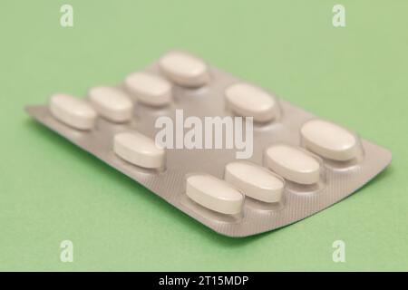 Goiânia, Goias, Brasile – 10 ottobre 2023: Un blister di plastica e alluminio con compresse su una superficie verde. Foto Stock