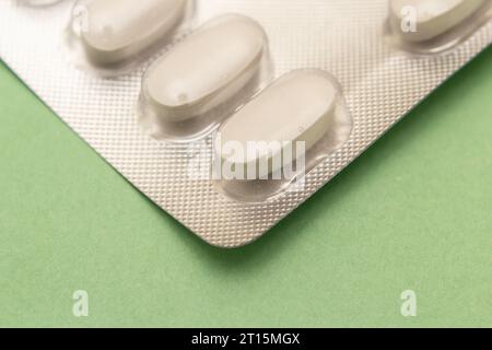 Goiânia, Goias, Brasile – 10 ottobre 2023: Un blister di plastica e alluminio con compresse su una superficie verde. Foto Stock