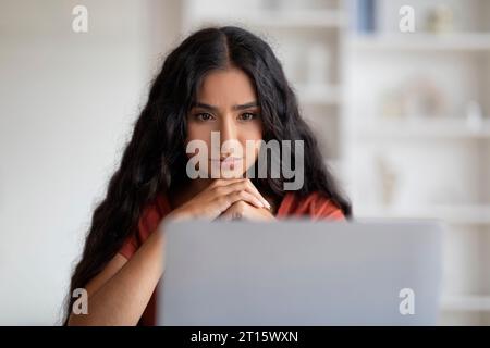 Giovane donna indiana libera professionista che lavora online, utilizzando un computer portatile Foto Stock