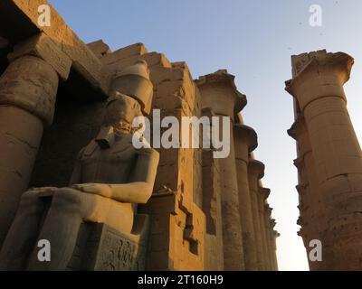 L'arenaria degli enormi colonnati e delle statue del Tempio di Luxor brilla d'oro al tramonto sulla riva orientale del Nilo. Foto Stock