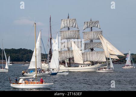 Kiel, Schleswig-Holstein, Germania. 24 giugno 2023. Il barque a tre alberi Artemis (parte posteriore centrale), costruito nel 1926, prende parte alla Tall Ships Parade (Windjammerparade) nella baia di Kieler Förde nel Mar Baltico con circa 60 navi alte, tradizionali velieri, piroscafi e centinaia di yacht a vela come parte della Kiel Week (Kieler Woche), un evento annuale di vela a Kiel. Foto Stock