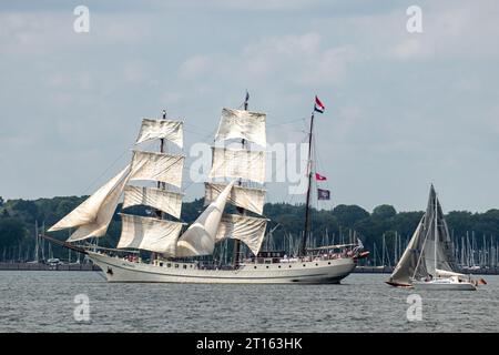 Kiel, Schleswig-Holstein, Germania. 24 giugno 2023. Il barque a tre alberi "Artemis" (centro), costruito nel 1926, partecipa alla Tall Ships Parade (Windjammerparade) nella baia di Kieler Förde nel Mar Baltico con circa 60 navi alte, tradizionali velieri, piroscafi e centinaia di yacht a vela nell'ambito della Kiel Week (Kieler Woche), un evento annuale di vela a Kiel. Foto Stock