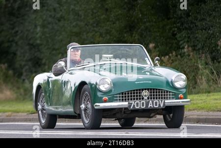 Bicester, Oxon., UK - 8 ottobre 2023: 1960 auto d'epoca Green Turner che guida su una strada di campagna inglese. Foto Stock