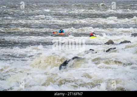 Due kayak di acqua bianca che giocano e si allenano sotto la diga di Low Water sul fiume Mississippi a Chain of Rocks vicino a St Louis, Missouri Foto Stock