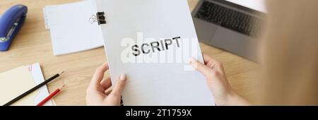 Mani di una donna che tiene documenti di sceneggiatura per le riprese di programmi televisivi Foto Stock