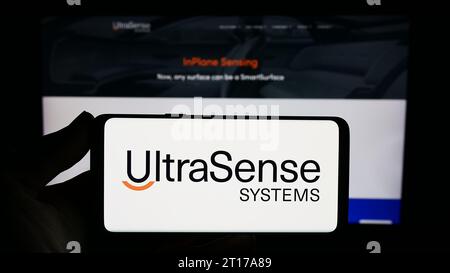 Persona che possiede uno smartphone con il logo della società statunitense UltraSense Systems Inc. Di fronte al sito Web. Concentrarsi sul display del telefono. Foto Stock