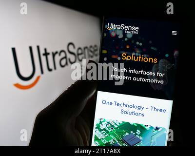 Persona che possiede il cellulare con la pagina Web della società statunitense UltraSense Systems Inc. Di fronte al logo. Concentrarsi sul centro del display del telefono. Foto Stock