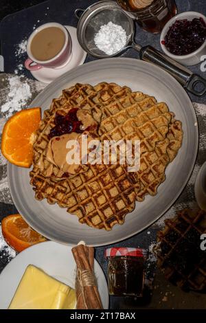 Waffle serviti con burro di arachidi e marmellata. Servizio fotografico con menu gastronomico. Scatto selettivo della messa a fuoco. Foto Stock