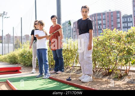 Bambini informali in un campo da golf con mazze da golf. Foto Stock