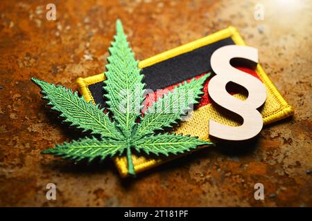 Cannabisblatt-Symbol und Paragrafenzeichen auf Deutschlandfahne, Cannabisgesetz Foto Stock