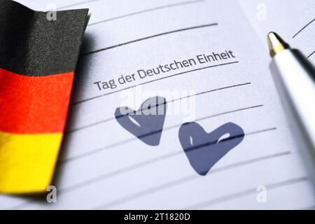 FOTOMONTAGE, Kalenderseite Tag der Deutschen Einheit mit deutscher Fahne und Herzen Foto Stock