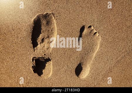 Schuh- und Fußabdruck im Sand, Symbolfoto equilibrio vita-lavoro Foto Stock
