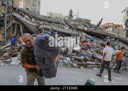 Rafah, territori palestinesi. 12 ottobre 2023. I palestinesi ispezionano gli edifici distrutti dopo gli attacchi aerei israeliani nella città di Gaza, mentre continuano i combattimenti tra le truppe israeliane e i militanti islamici di Hamas. Crediti: Abed Rahim Khatib/dpa/Alamy Live News Foto Stock