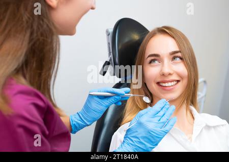Bella paziente donna in visita dal dentista per controllare i denti. Trattamento dei denti Foto Stock