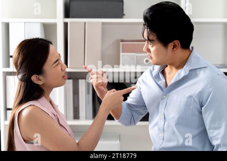 Una donna d'affari asiatica arrabbiata urlava e rimproverava a un uomo d'affari pazzo nell'ambiente dell'ufficio. Si stanno puntando il dito l'uno contro l'altro.- lotta per affari e conflitto sul concetto di posto di lavoro Foto Stock