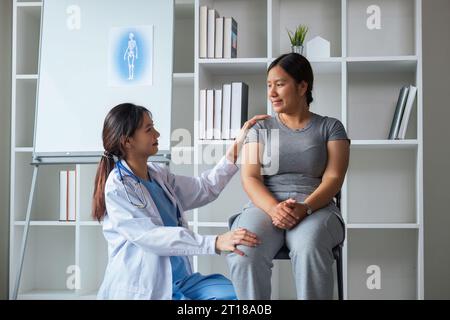 Donna in sovrappeso che ha un medico di consultazione alla clinica. ritratto di un medico sorridente che mette la mano sulla spalla che sostiene il paziente, dando Foto Stock