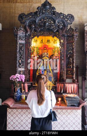 Adoratore che prega di fronte all'altare Mon Quan Vuong, alla pagoda Thien Hau, alla città di ho chi Minh, Vietnam. Foto Stock
