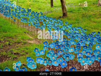 Sculture in ceramica dipinte a mano dei papaveri blu dell'Himalaya dell'artista Anna Whitehouse in mostra nel giardino e parco delle sculture dell'Himalaya. Inghilterra, Regno Unito. Foto Stock