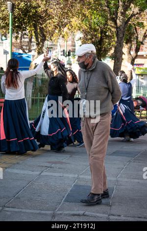 La Paz, Bolivia - 8 agosto 2022: Vecchio che indossa una maschera nera sotto il naso e una bottiglia di alcol disinfettante appeso al collo Foto Stock