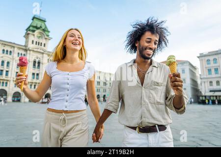 Una coppia si diverte a mangiare un gelato e a fare una passeggiata nel centro città Foto Stock