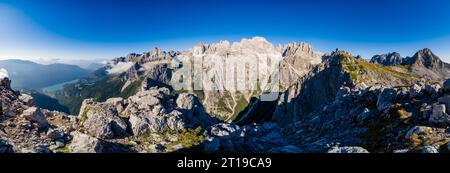 Vista panoramica delle pareti rocciose e delle cime della catena principale delle Dolomiti di Brenta e del lago di Molveno in lontananza, vista da Croz dell'altissimo. Foto Stock
