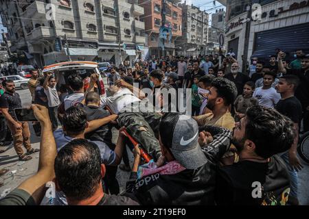 Rafah, territori palestinesi. 12 ottobre 2023. I soccorritori trasportano i corpi delle vittime di un attacco aereo israeliano, mentre il conflitto tra le truppe israeliane e i militanti di Hamas continua. Crediti: Abed Rahim Khatib/dpa/Alamy Live News Foto Stock