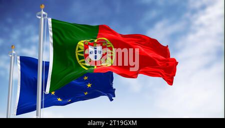 Bandiere del Portogallo che sventolano con bandiere dell'Unione europea in una giornata limpida. Democrazia e politica. Tessuto ondulato, rendering di illustrazioni 3D. Messa a fuoco selettiva Foto Stock
