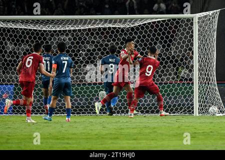 Giacarta, Indonesia. 12 ottobre 2023. I giocatori indonesiani celebrano il punteggio durante il primo turno delle qualificazioni ai Mondiali di calcio 2026 in Asia tra Indonesia e Brunei Darussalam allo stadio Gelora Bung Karno di Giacarta, Indonesia, il 12 ottobre 2023. Credito: Agung Kuncahya B./Xinhua/Alamy Live News Foto Stock