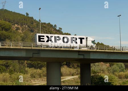 Un veicolo sta attraversando il ponte, con l'iscrizione sul rimorchio - esportazione. Concetto di logistica. Foto Stock