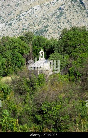 Piccola chiesa in pietra in un legno di Bosnia ed Erzegovina Foto Stock