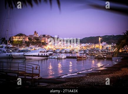 Un porto pieno di barche di notte. Foto di un vivace porto pieno di barche illuminate di notte nelle isole Eolie della Sicilia Foto Stock