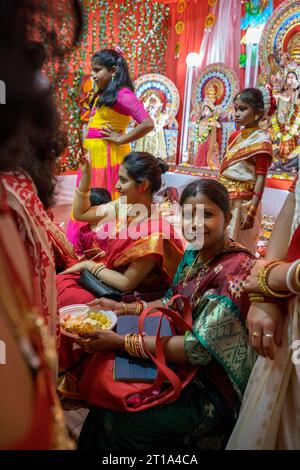 Roma, Torpignattara: Celebrazione della festa indiana di Durga Puja nel quartiere romano di Tor Pignattara. Una donna indiana si siede e guarda lo spettacolo Foto Stock