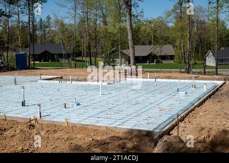 CROW WING CO, Minnesota - 10 MAGGIO 2023: Primo piano del cantiere di costruzione di abitazioni con isolamento sul pavimento di cemento, in un bellissimo lotto di edificio nuovo Foto Stock