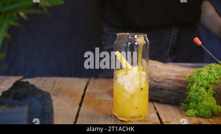 Primo piano per un cocktail freddo estivo. Cocktail con frutto della passione, mango e cubetti di ghiaccio in un bicchiere. Cocktail tradizionale italiano. Il processo di maki Foto Stock