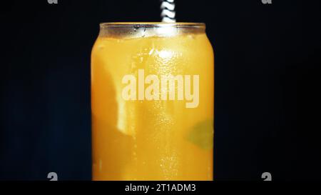 Primo piano per un cocktail freddo estivo. Cocktail con frutto della passione, mango e cubetti di ghiaccio in un bicchiere. Cocktail tradizionale italiano. Il processo di maki Foto Stock