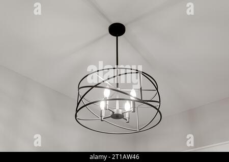 Moderno impianto di illuminazione rotondo in metallo per fattorie con asta nera e soffitto bianco pulito vuoto Foto Stock