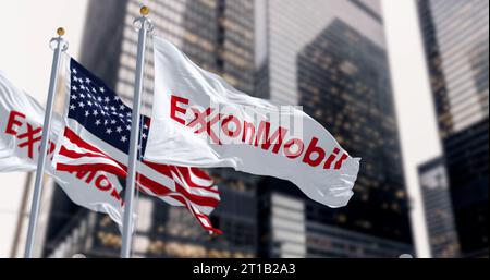 Spring, US, 5 ottobre 2023: ExxonMobil e le bandiere americane sventolano nel vento in un distretto finanziario. Multinazionale americana del petrolio e del gas. Foto Stock