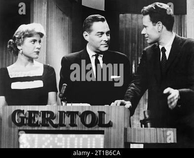 Il conduttore del quiz show "ventuno" Jack Barry si rivolge verso il concorrente Charles Van Doren nei panni di un altro concorrente Vivienne che si avvicina agli sguardi, NBC Studios, New York, New York, USA, Orlando Fernandez, New York World-Telegram e The Sun Newspaper Photography Collection, 11 marzo 1957 Foto Stock