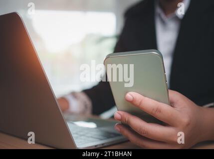 Pagina del sito Web, contattaci o inviaci un'e-mail di marketing, hotline di assistenza clienti, contattaci. Donna d'affari seduta e al lavoro su smartphone e computer Foto Stock