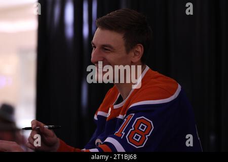 Edmonton, Alberta, Canada. 12 ottobre 2023. Edmonton Oilers ZACH HYMAN (#18) parla con un tifoso mentre firma autografi al West Edmonton Mall durante un evento per iniziare la stagione 2023-2024 della NHL. (Immagine di credito: © Alexander Patton/ZUMA Press Wire) SOLO USO EDITORIALE! Non per USO commerciale! Foto Stock