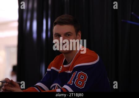 Edmonton, Alberta, Canada. 12 ottobre 2023. Edmonton Oilers ZACH HYMAN (#18) condivide un sorriso mentre firma gli autografi al West Edmonton Mall durante un evento per iniziare la stagione 2023-2024 della NHL. (Immagine di credito: © Alexander Patton/ZUMA Press Wire) SOLO USO EDITORIALE! Non per USO commerciale! Foto Stock