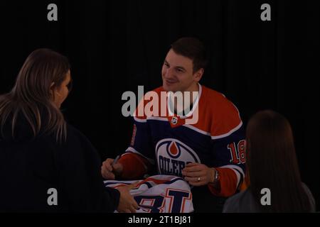 Edmonton, Alberta, Canada. 12 ottobre 2023. Edmonton Oilers ZACH HYMAN (#18) parla con un tifoso mentre firma autografi al West Edmonton Mall durante un evento per iniziare la stagione 2023-2024 della NHL. (Immagine di credito: © Alexander Patton/ZUMA Press Wire) SOLO USO EDITORIALE! Non per USO commerciale! Foto Stock