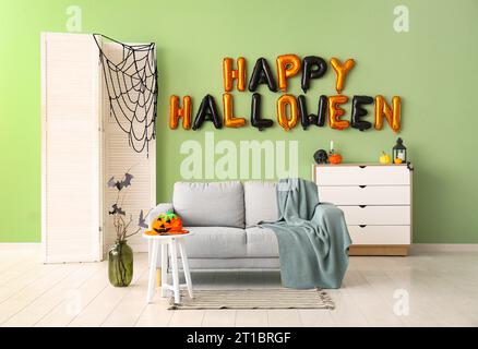 Interno del soggiorno decorato per Halloween con palloncini e divano Foto Stock