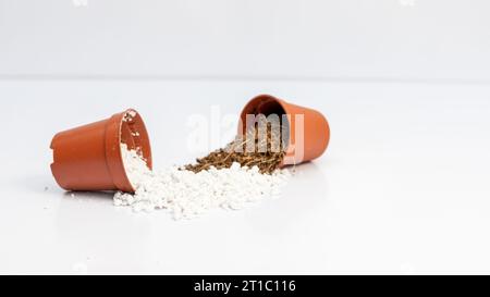 Miscela di perlite e cocco in polvere in piccoli vasi isolati su fondo bianco Foto Stock