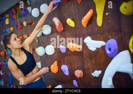 ritratto di una donna sportiva in una sala per arrampicata su massi Foto Stock