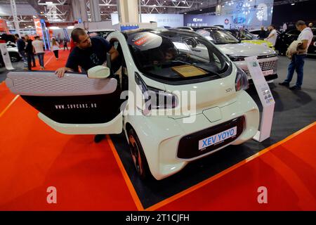 Bucarest, Romania. 12 ottobre 2023. I visitatori guardano un'auto elettrica XEV YOYO?durante la 20a edizione del Bucarest Car Show 2023 (SAB) a Bucarest, Romania, 12 ottobre 2023. Più di 40 aziende internazionali hanno presentato i loro veicoli convenzionali, ibridi ed elettrici, oltre a vari accessori per auto. Credito: Cristian Cristel/Xinhua/Alamy Live News Foto Stock